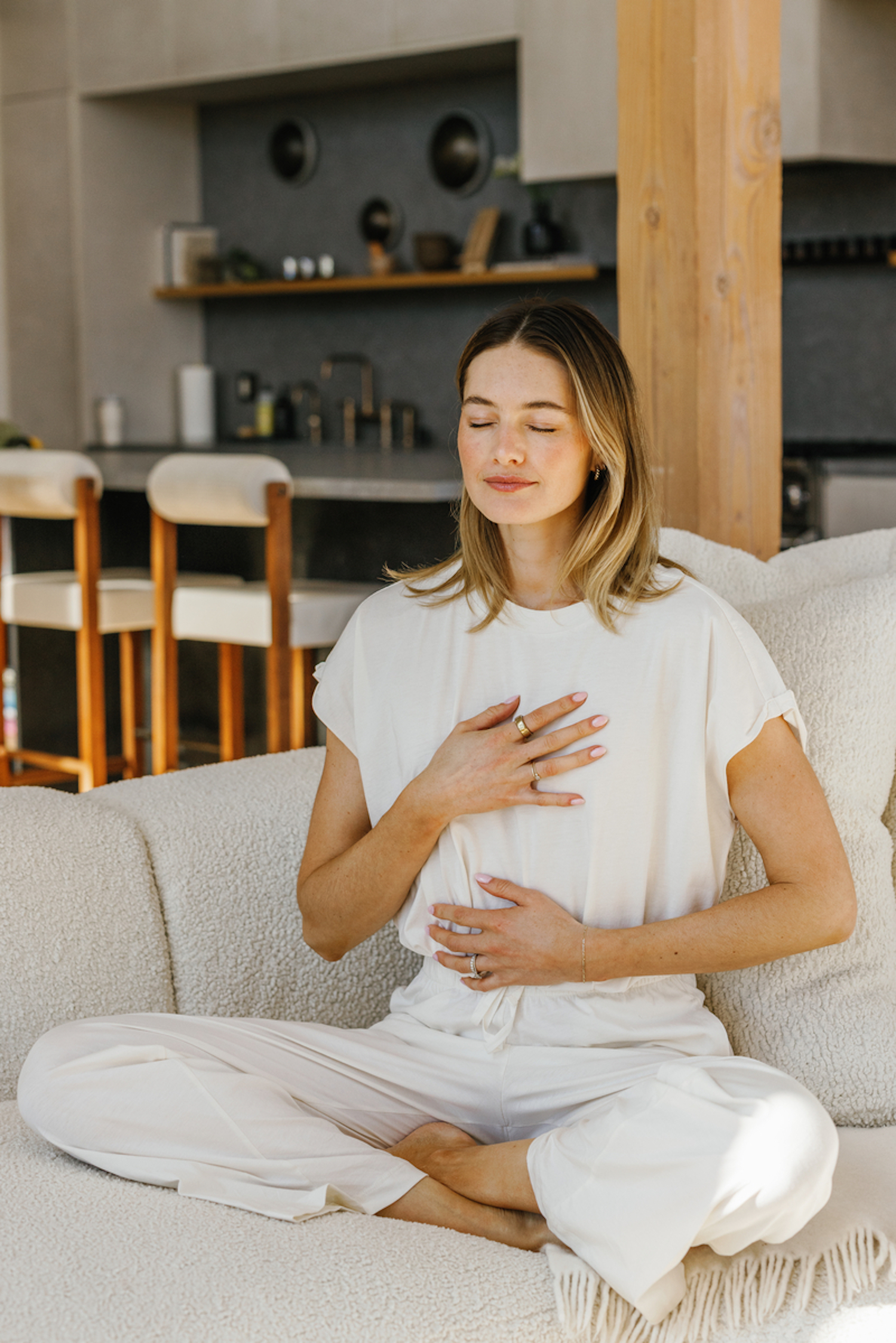 Woman meditating on the couch.